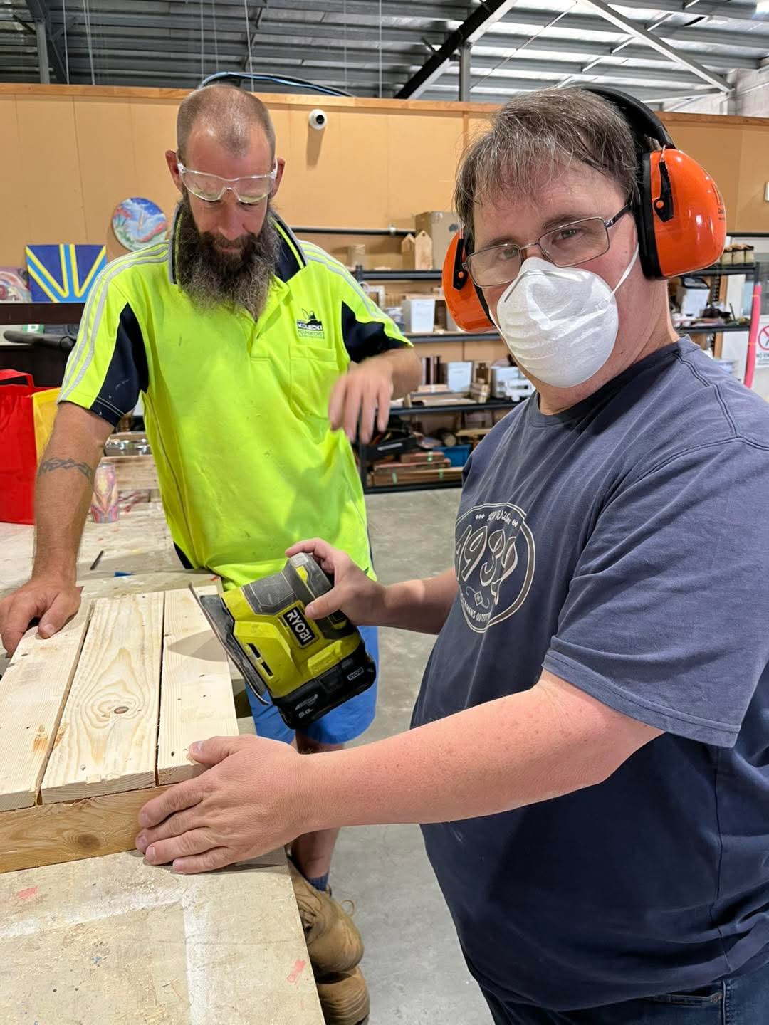 Participant using a sander with support in a workshop